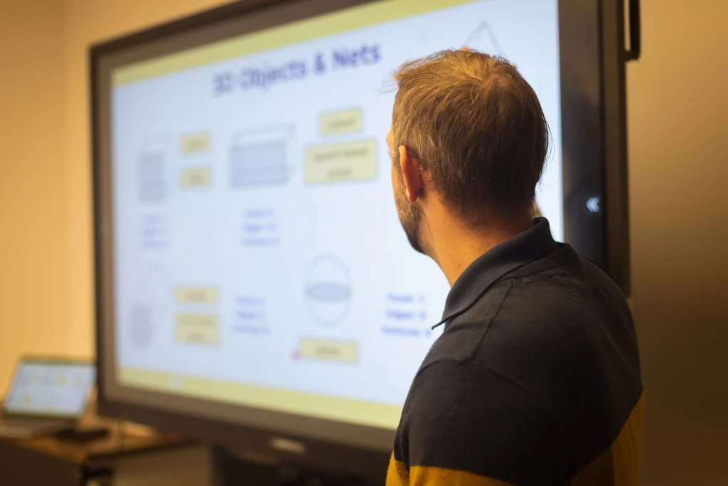 Daniel Collick reviewing maths lesson content on an interactive screen