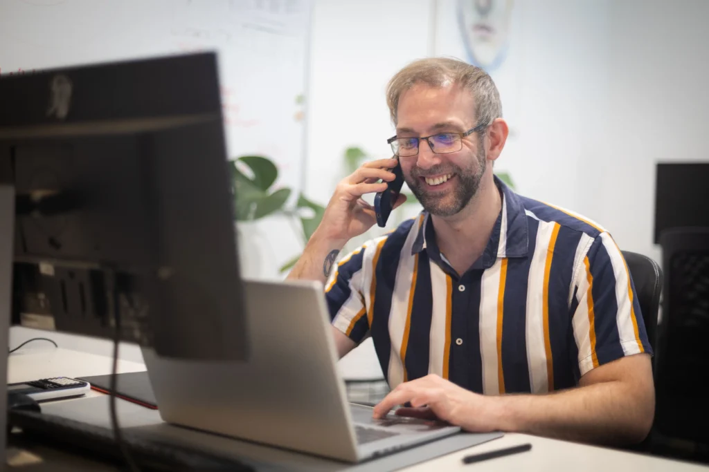 Daniel Collick from PeerPath speaking on the phone while working at his laptop