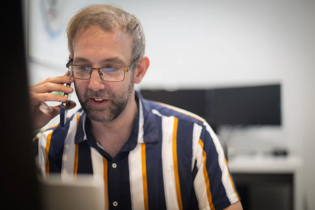 Daniel Collick from PeerPath taking a phone call at his desk